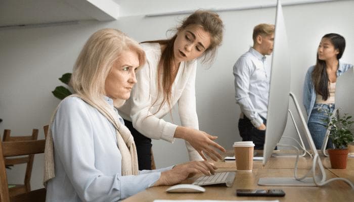 older woman getting lectured about computers